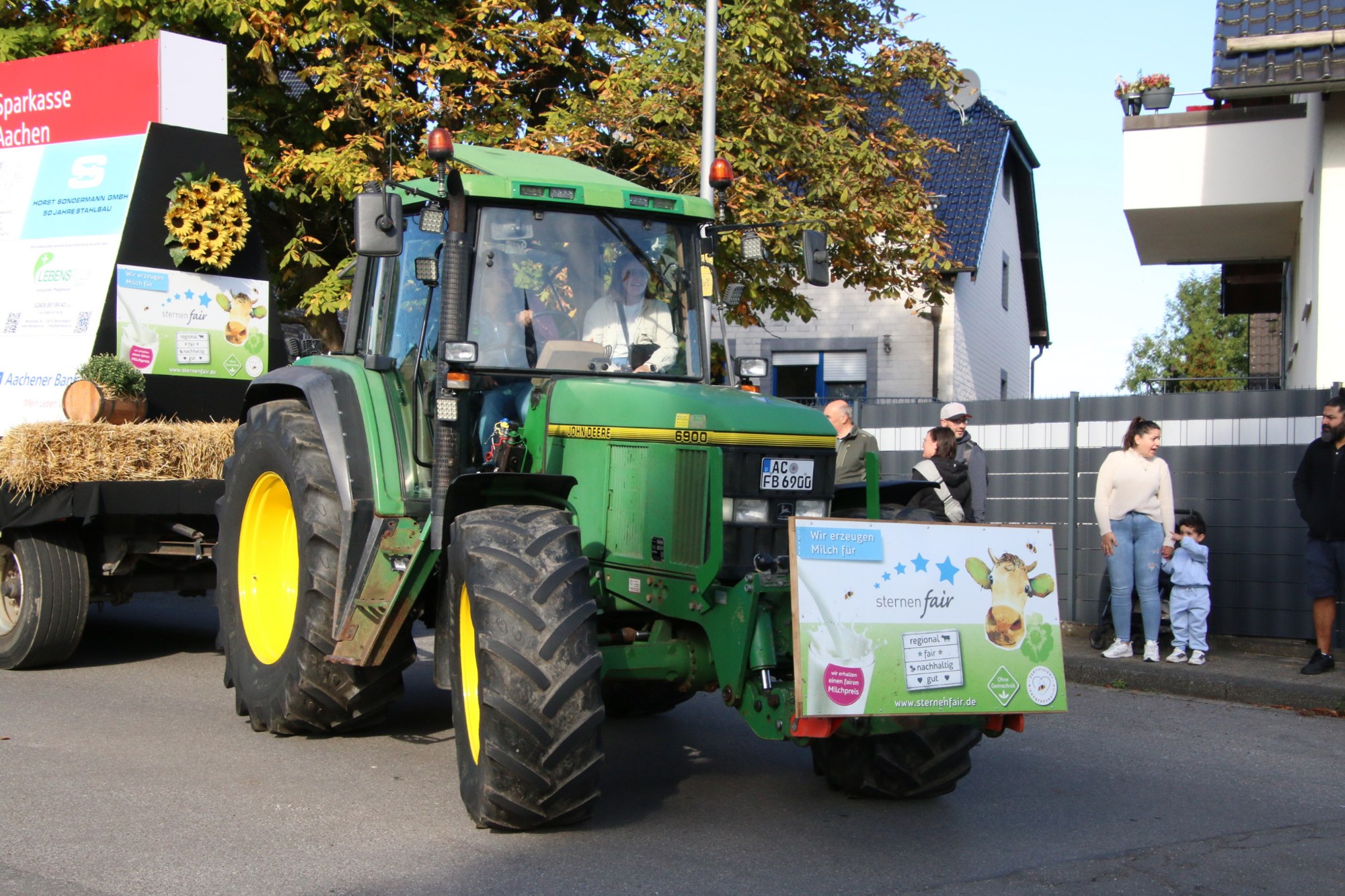 Geschmückter grüner Traktor vor Zuschauern beim Erntedankzug Walheim 2026.