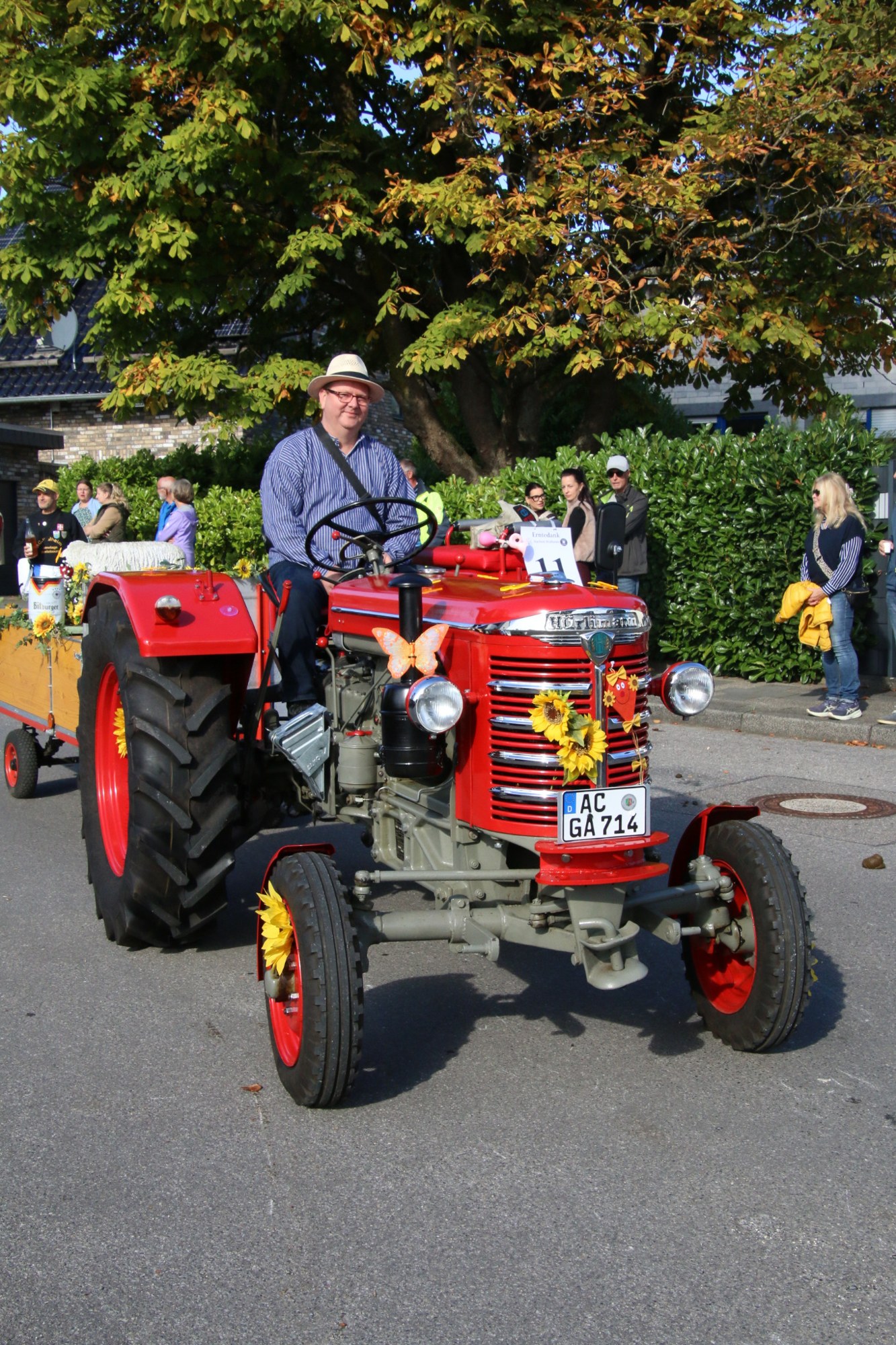Blumengeschmückter roter Traktor beim Erntedankzug Walheim 2026.