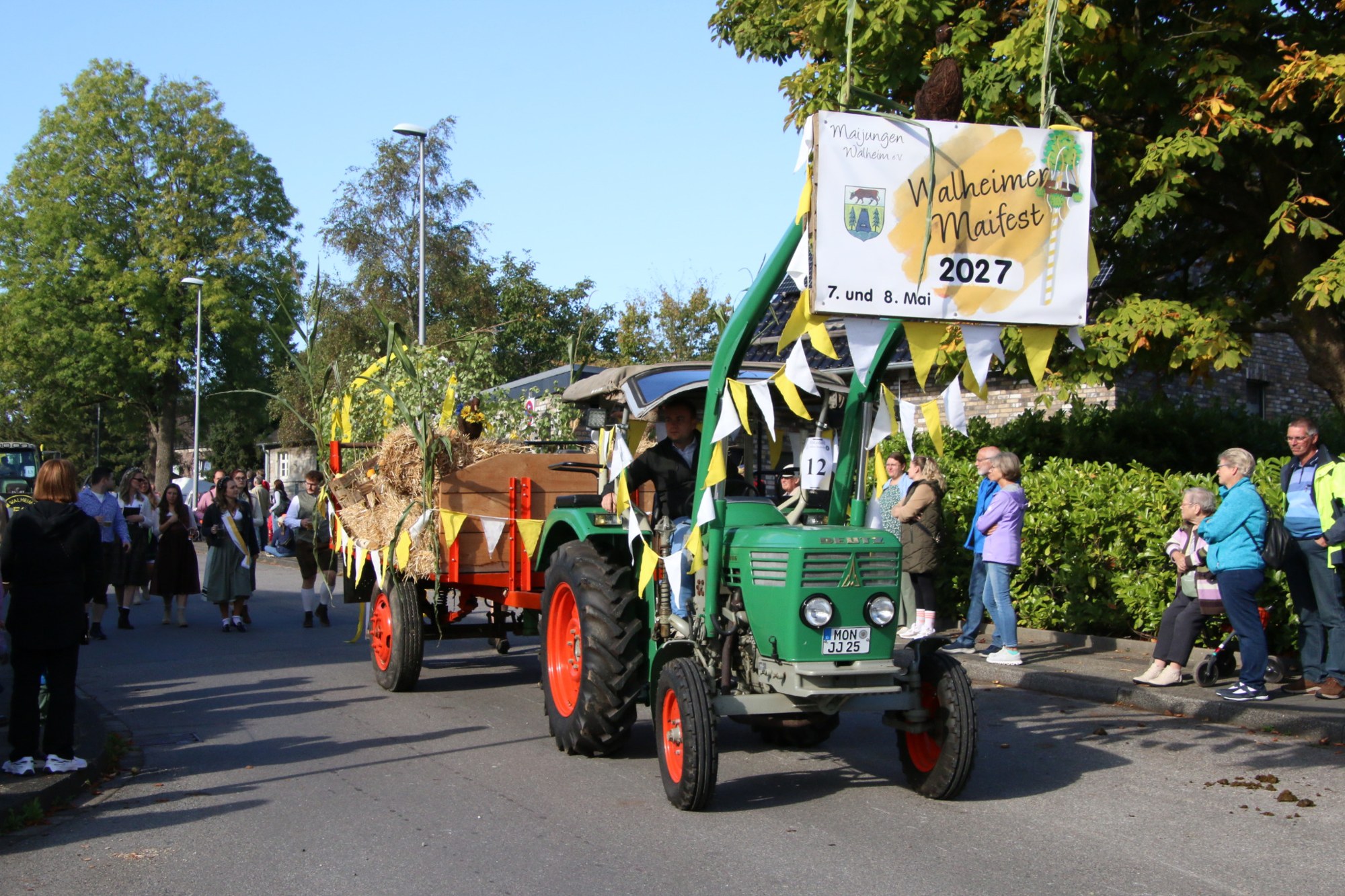 Grüner Traktor mit bunt geschmücktem Wagen beim Erntedankzug Walheim 2026.