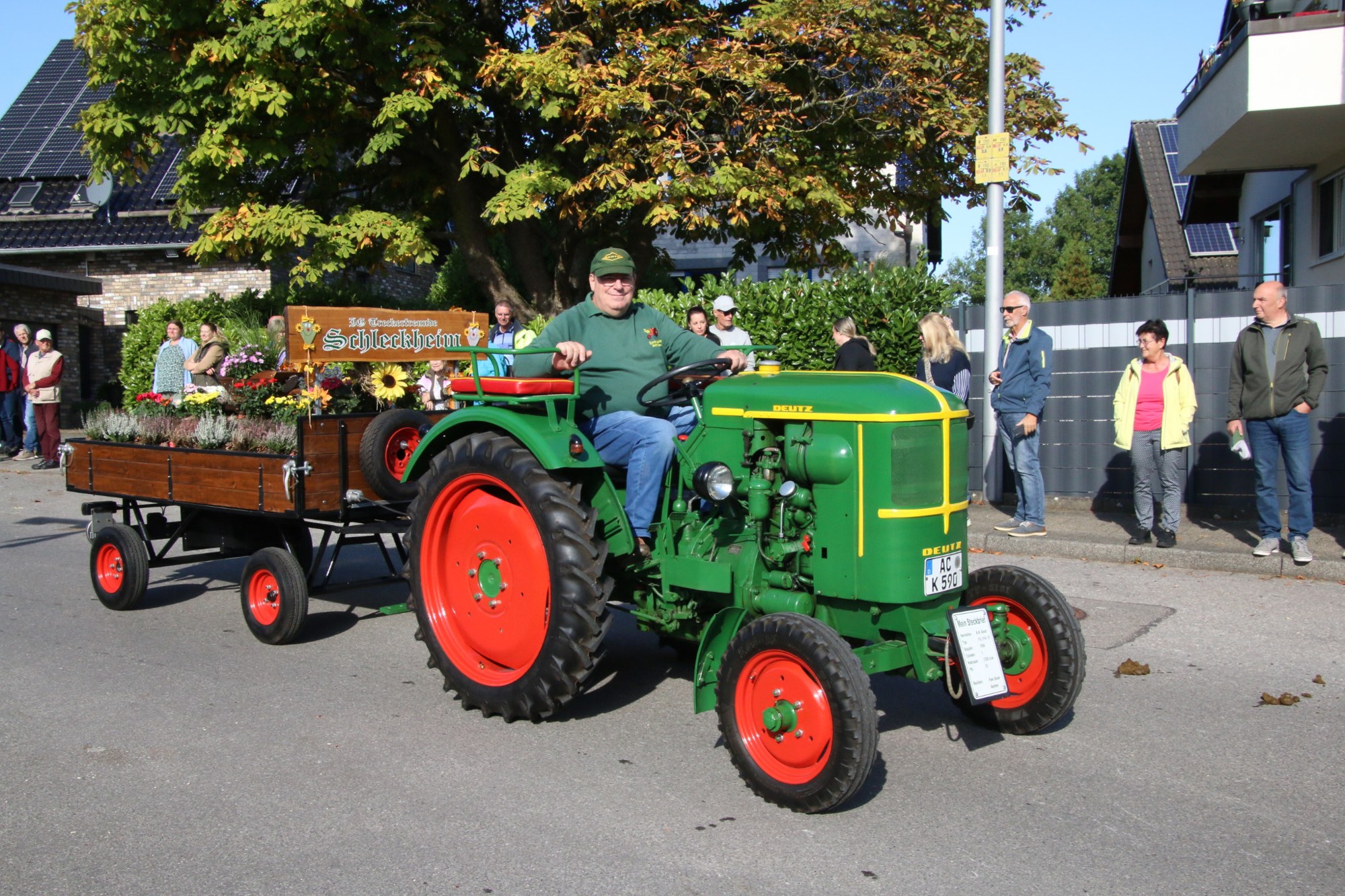 Grüner Traktor mit Erntewagen beim Erntedankzug Walheim 2026.
