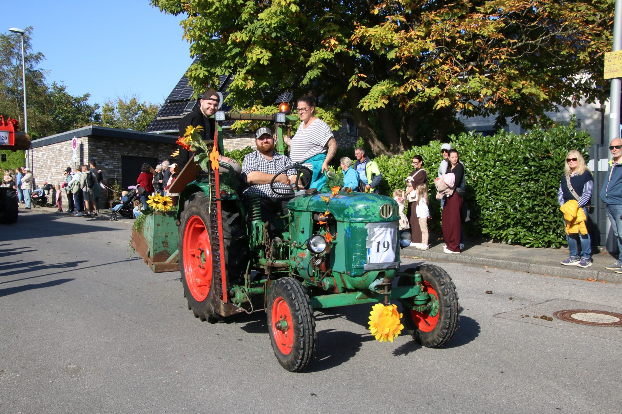 Grüner Traktor mit Blumenschmuck beim Erntedankzug Walheim 2026.