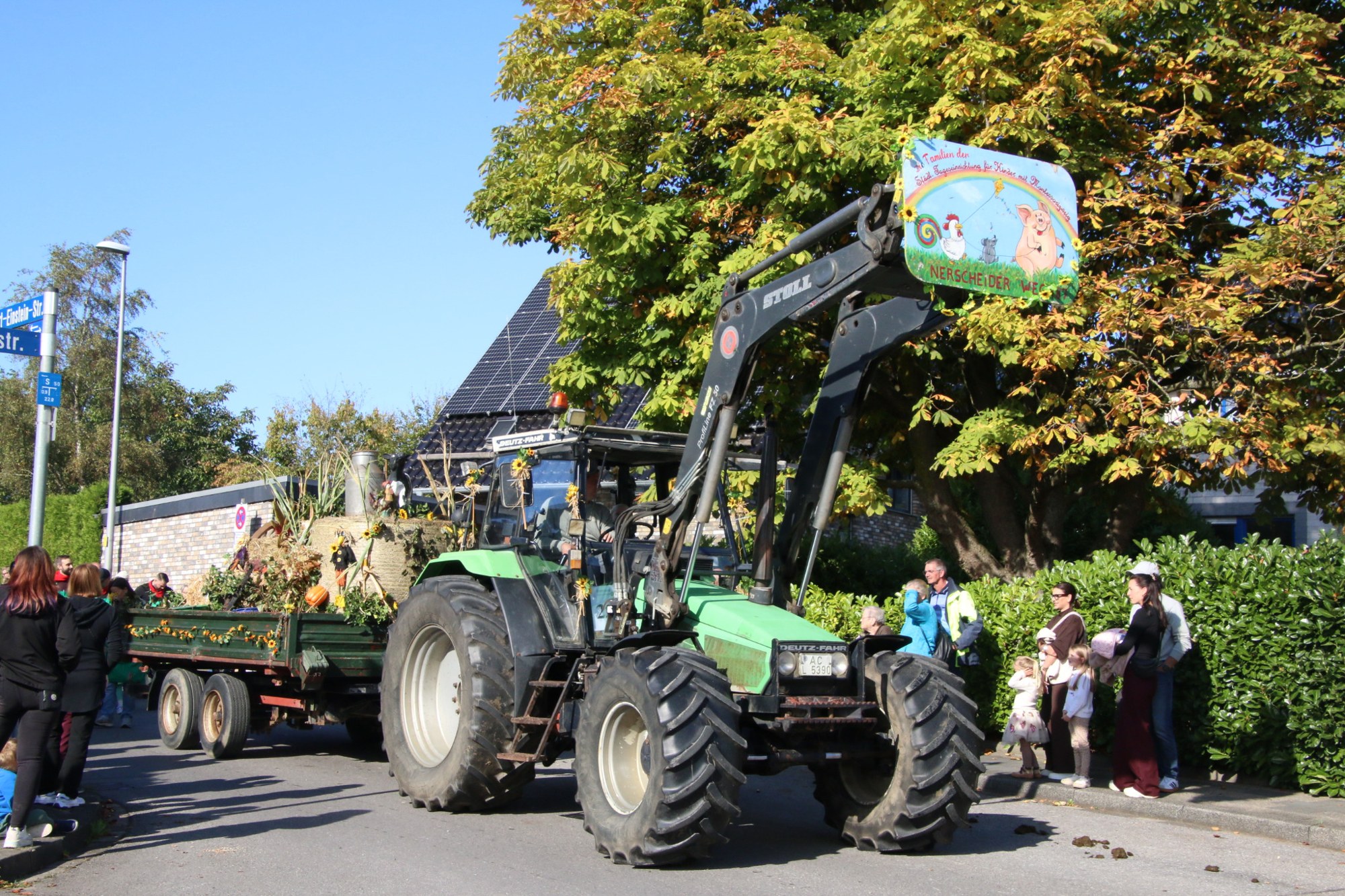 Grüner Traktor mit erhobener Schaufel beim Erntedankzug Walheim 2026.