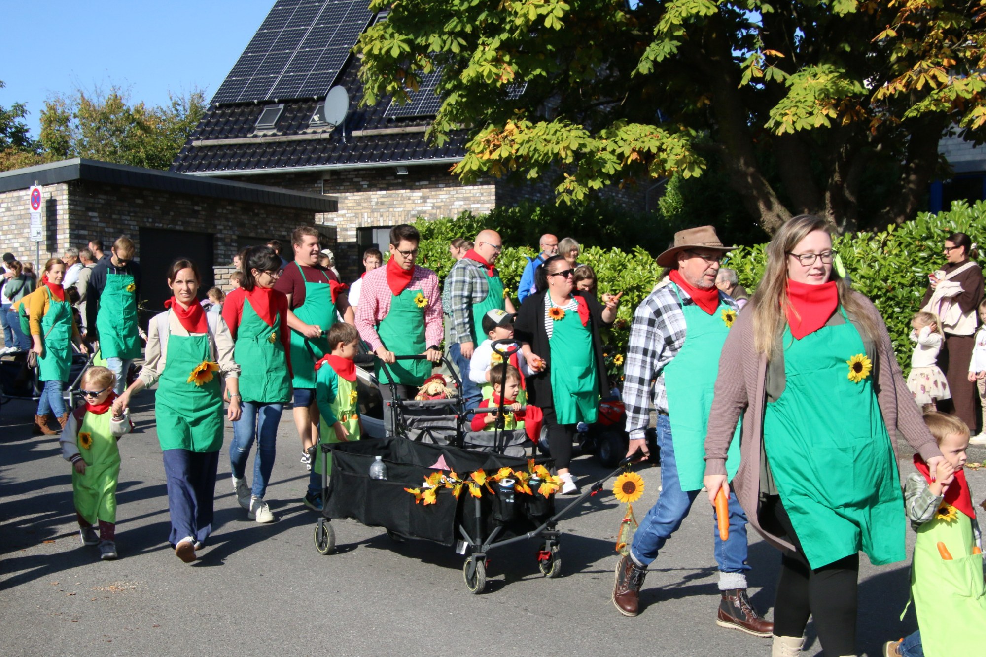 Kinder und Erwachsene mit grünen Halstüchern beim Erntedankzug Walheim 2026.