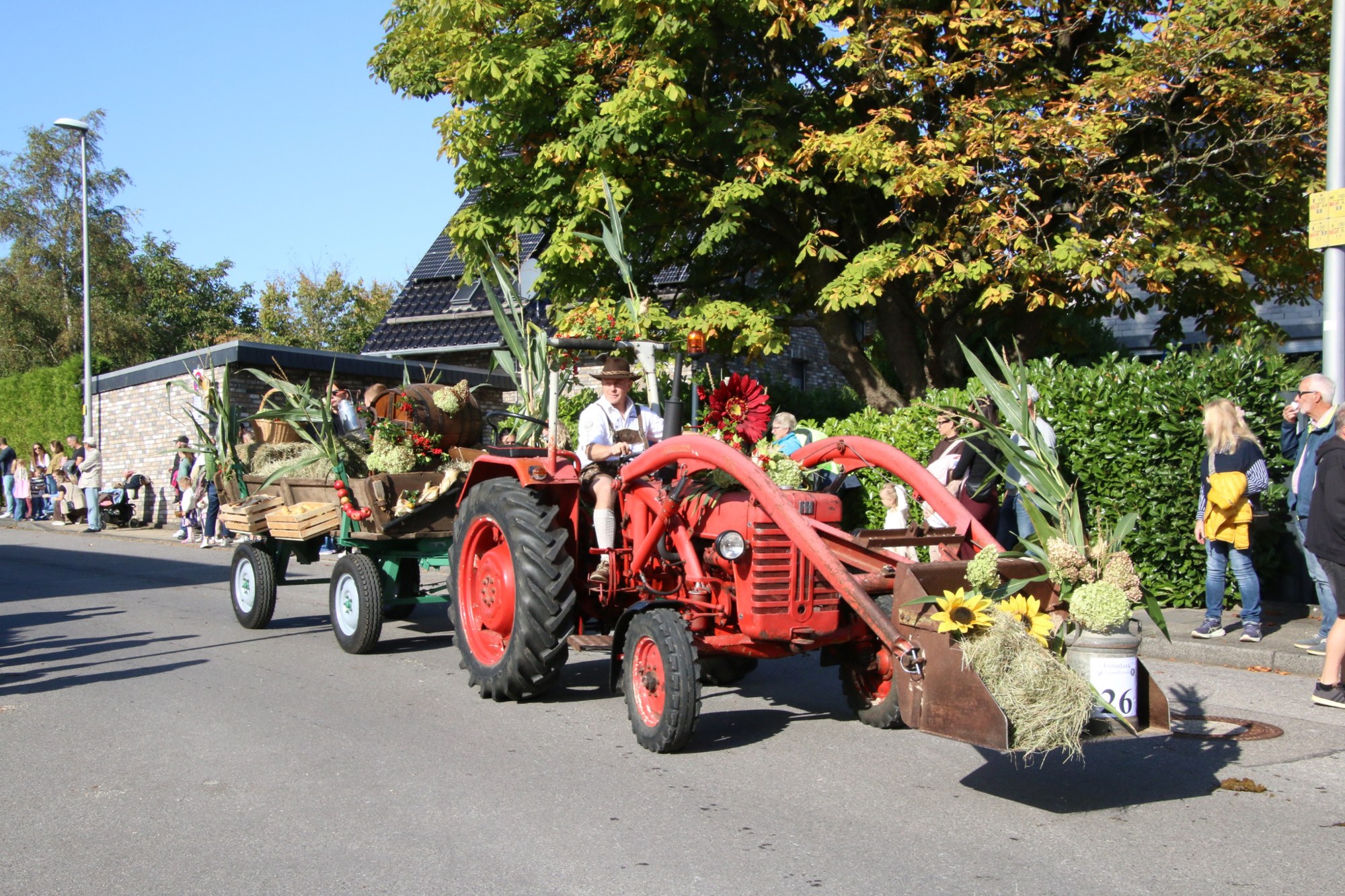 Roter Traktor mit Erntewagen beim Erntedankzug Walheim 2026.