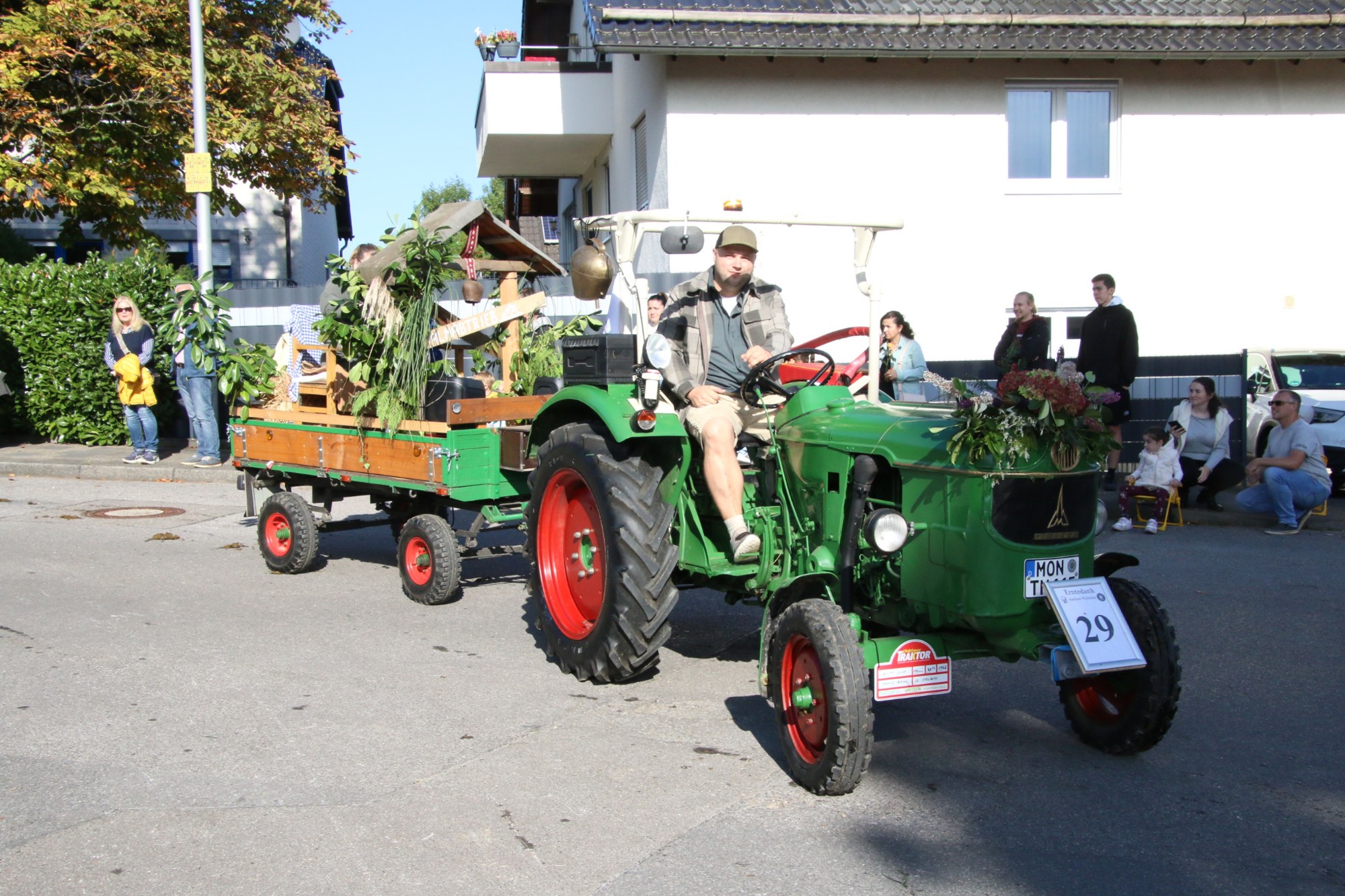 Grüner Traktor mit Blumenanhänger beim Erntedankzug Walheim 2026.