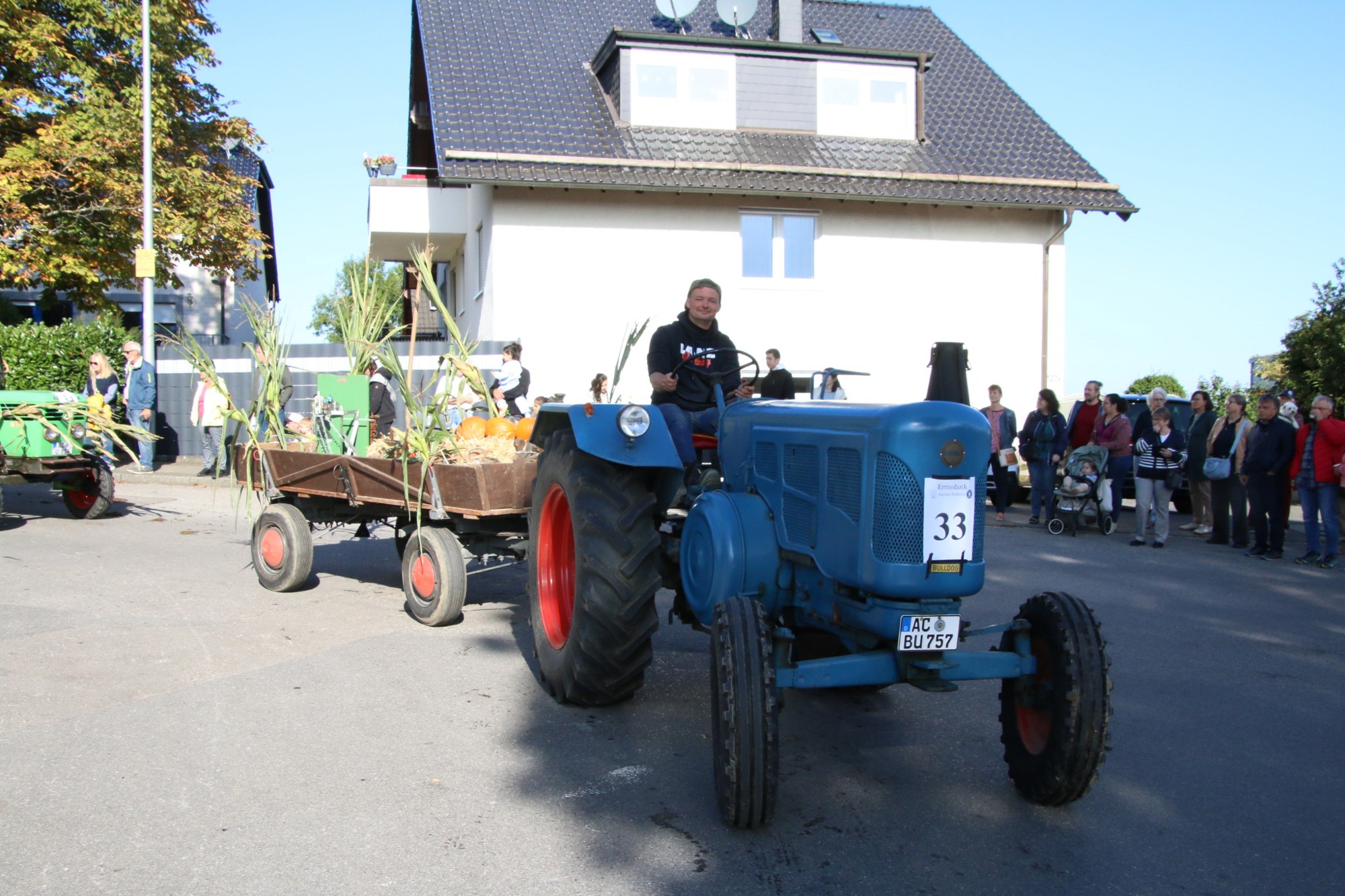 Blauer Oldtimertraktor mit Erntewagen beim Erntedankzug Walheim 2026.