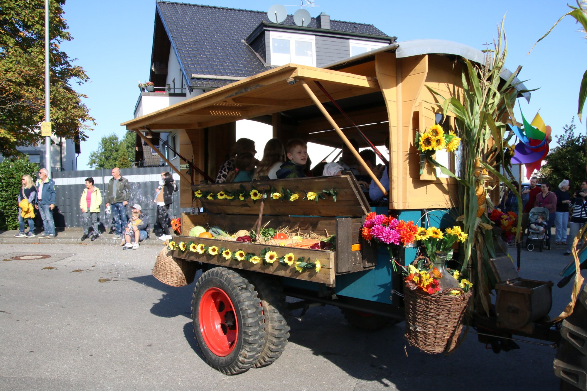 Hölzerner Festwagen mit Blumen beim Erntedankzug Walheim 2026.