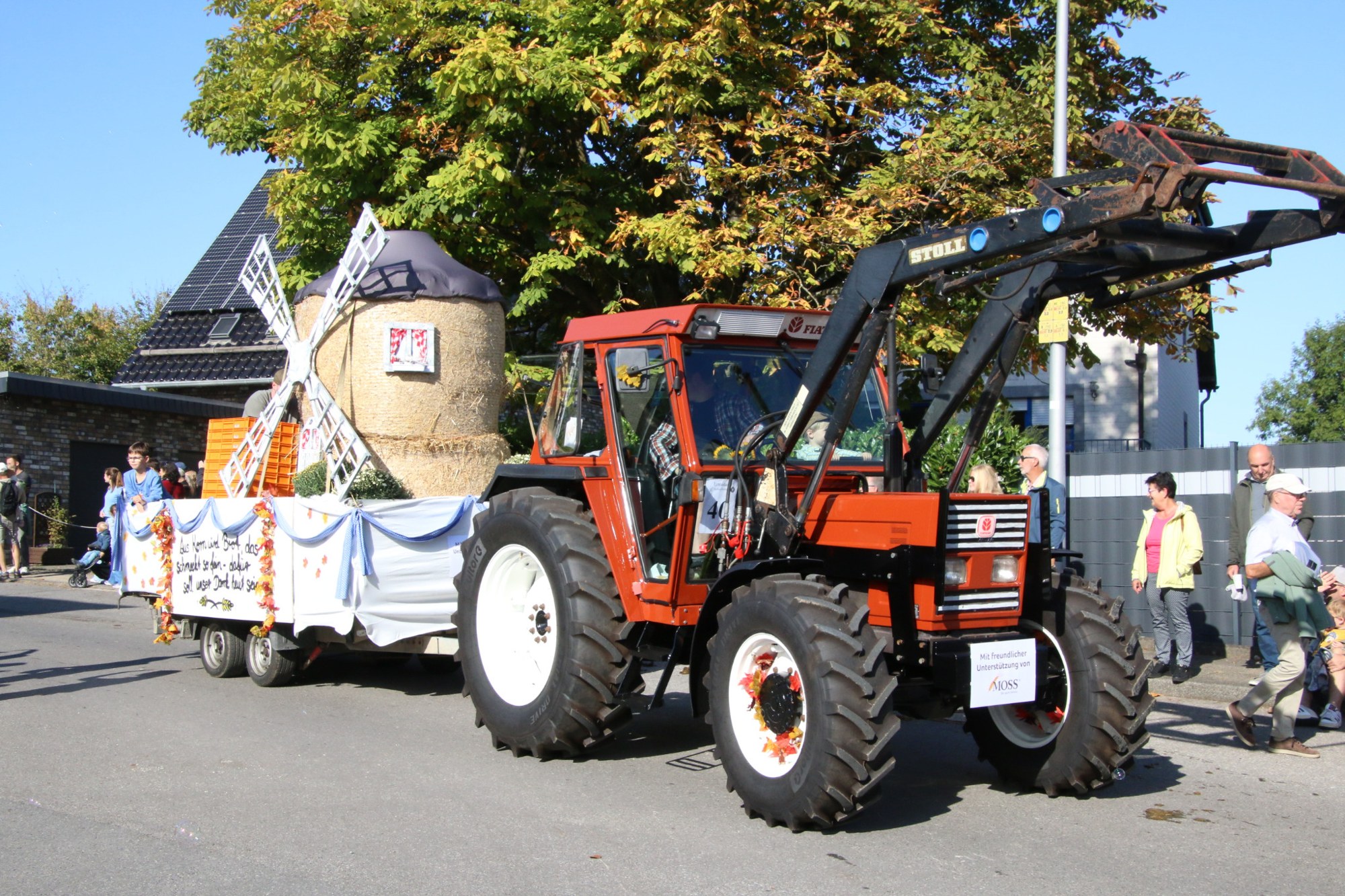 Traktor vor einem Wagen mit Windmühle beim Erntedankzug Walheim 2026.