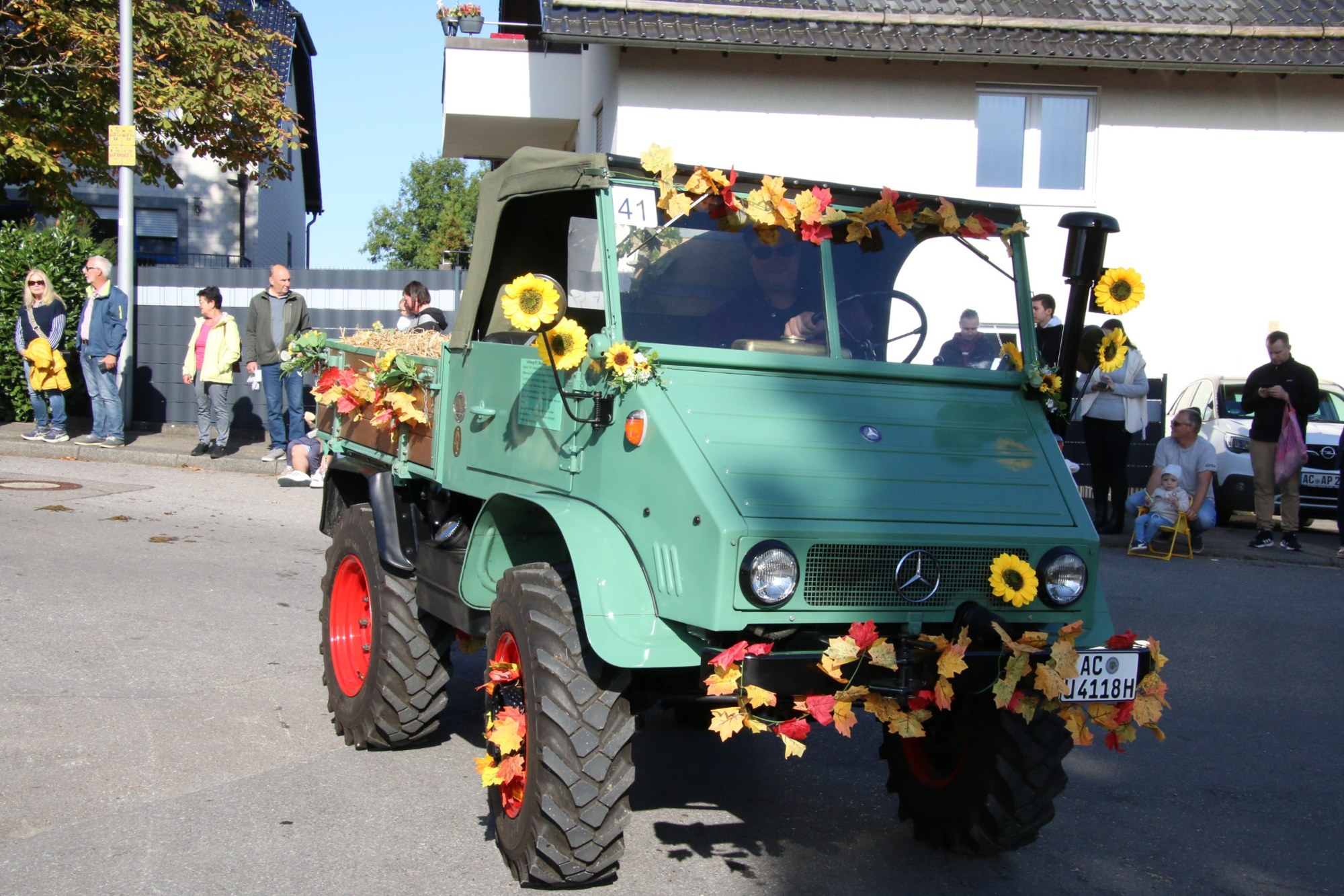 Grünes Nutzfahrzeug mit Sonnenblumen beim Erntedankzug Walheim 2026.