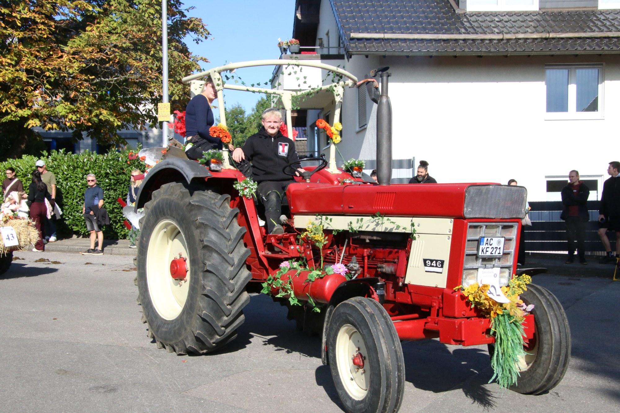 Roter Traktor mit Ernteanhänger beim Erntedankzug Walheim 2026.