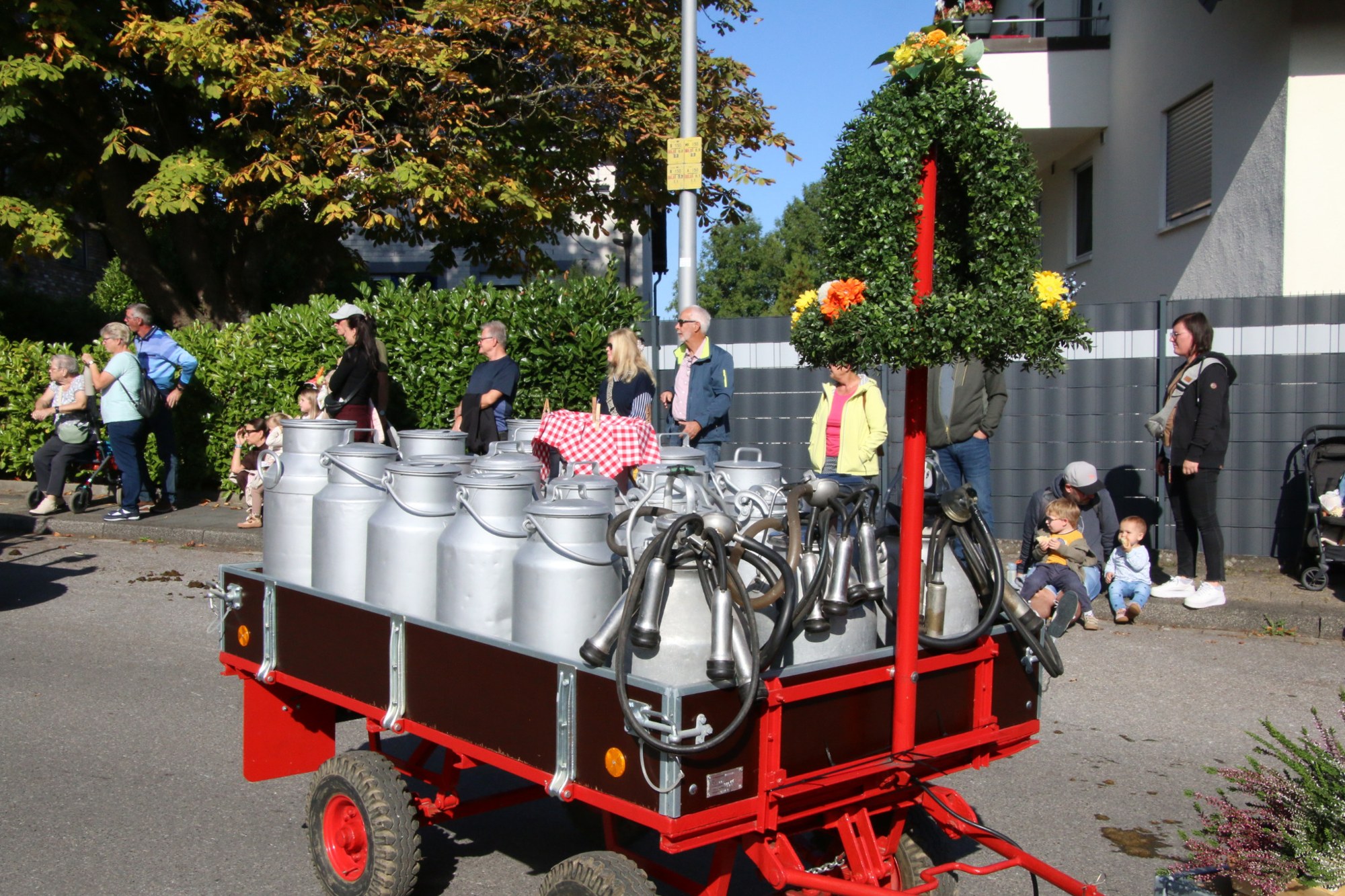 Milchkannen auf einem roten Erntewagen beim Erntedankzug Walheim 2026.