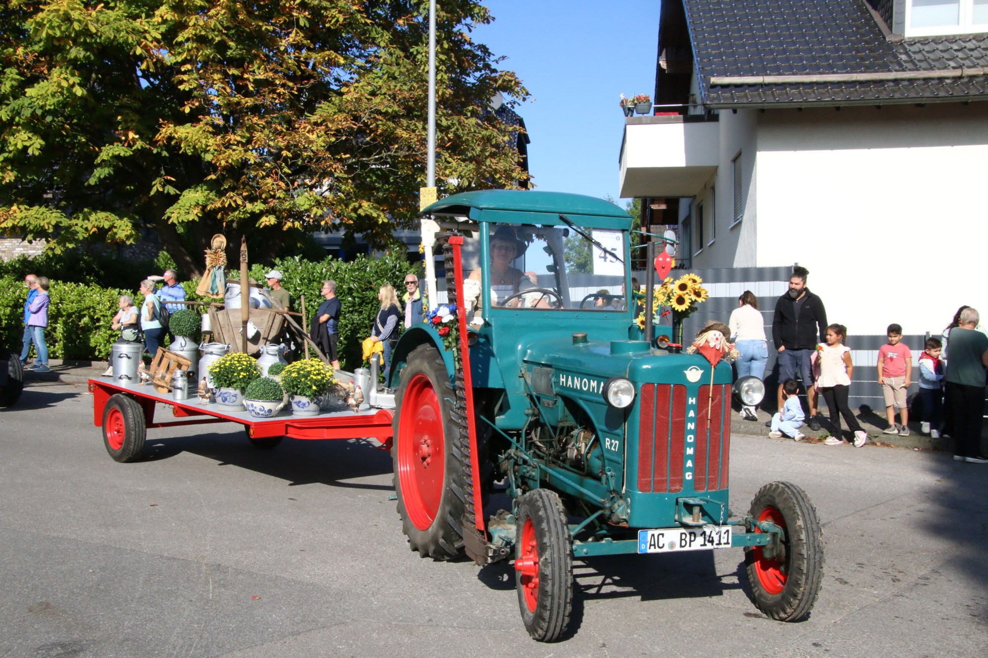 Blauer Traktor mit geschmücktem Anhänger beim Erntedankzug Walheim 2026.