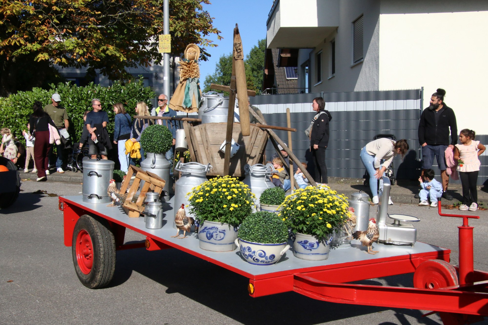 Roter Wagen mit Milchkannen und Erntegaben beim Erntedankzug Walheim 2026.