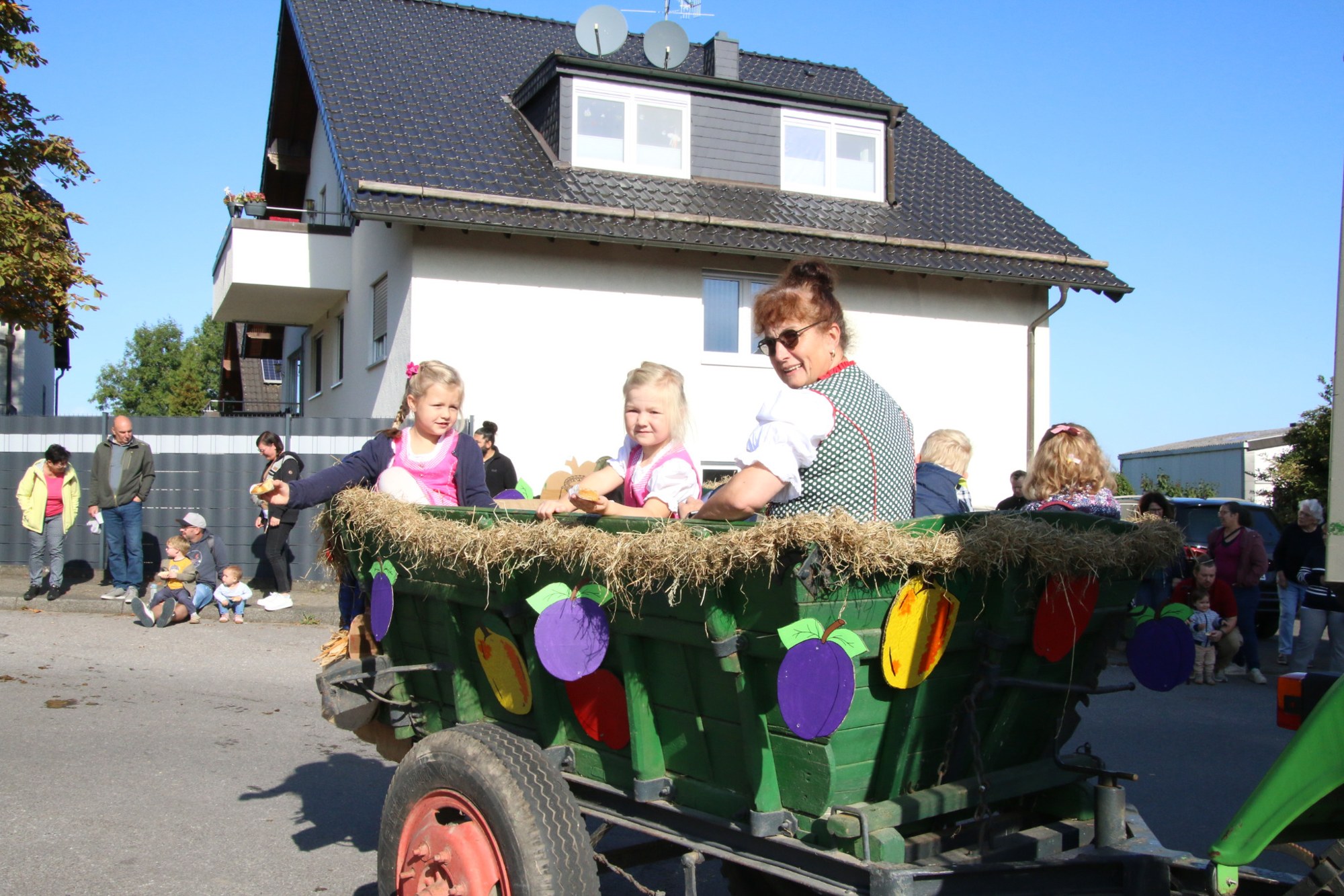 Kinder auf einem blumengeschmückten Wagen beim Erntedankzug Walheim 2026.