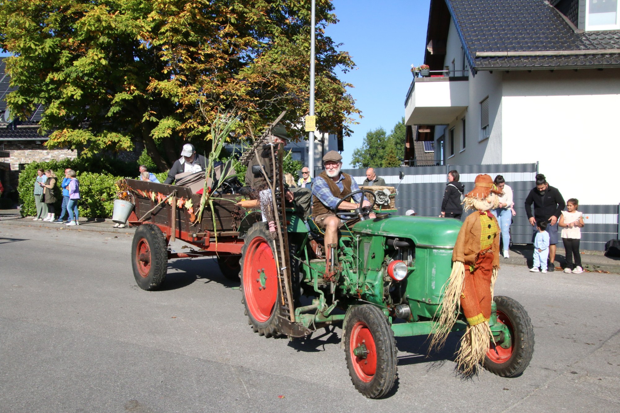 Grüner Traktor mit geschmücktem Anhänger beim Erntedankzug Walheim 2026.