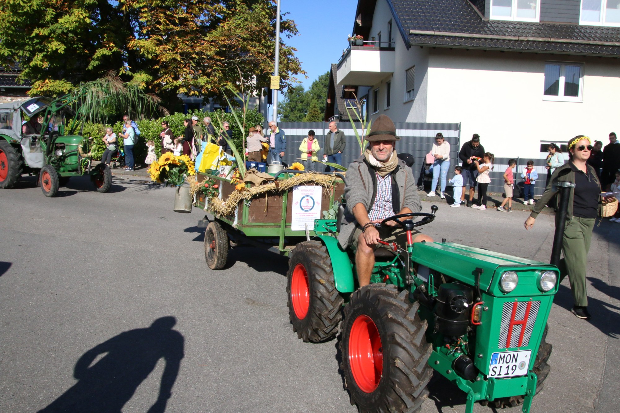 Grüner Traktor mit Erntewagen beim Erntedankzug Walheim 2026.