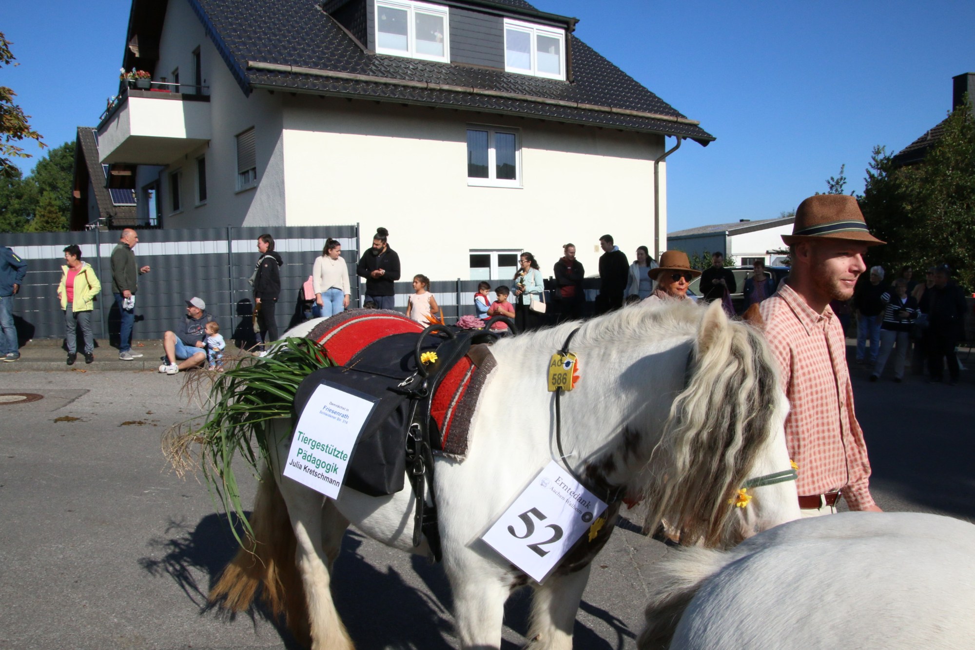Begleiter neben einem hellen Pferd beim Erntedankzug Walheim 2026.