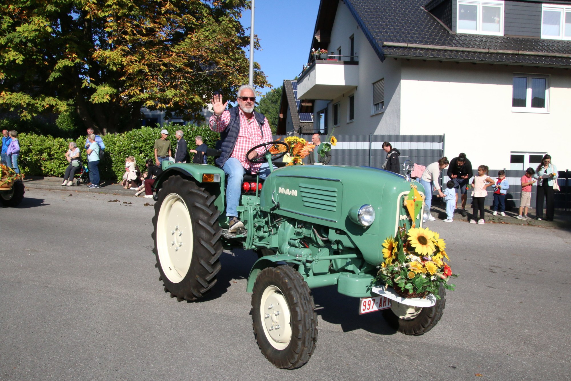 Hellgrüner Traktor mit Sonnenblumen beim Erntedankzug Walheim 2026.