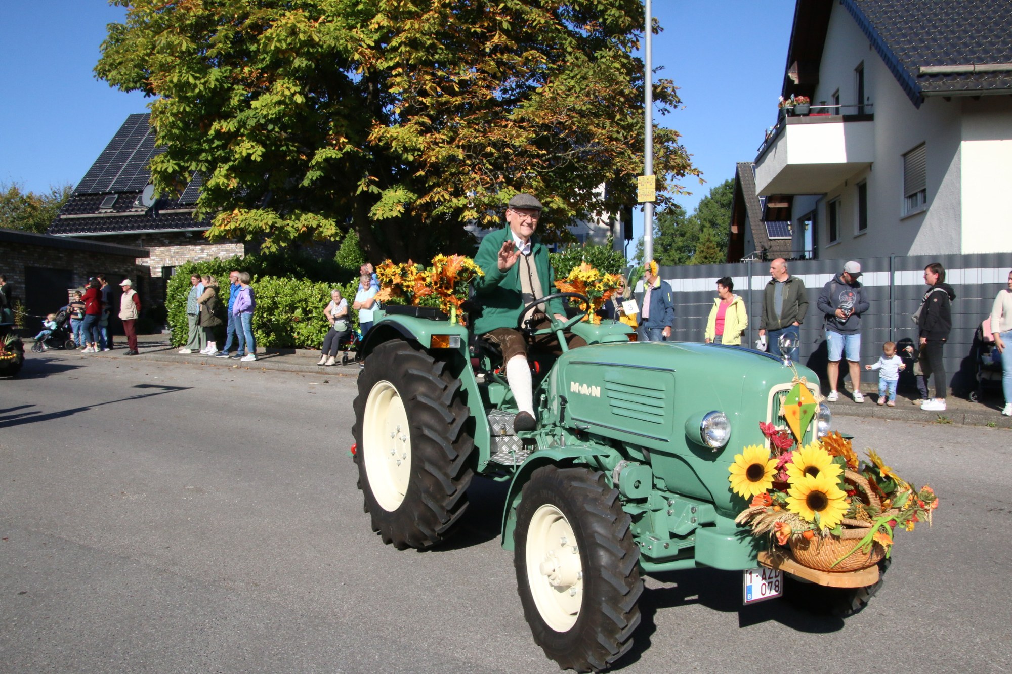 Hellgrüner Traktor vor Zuschauern beim Erntedankzug Walheim 2026.