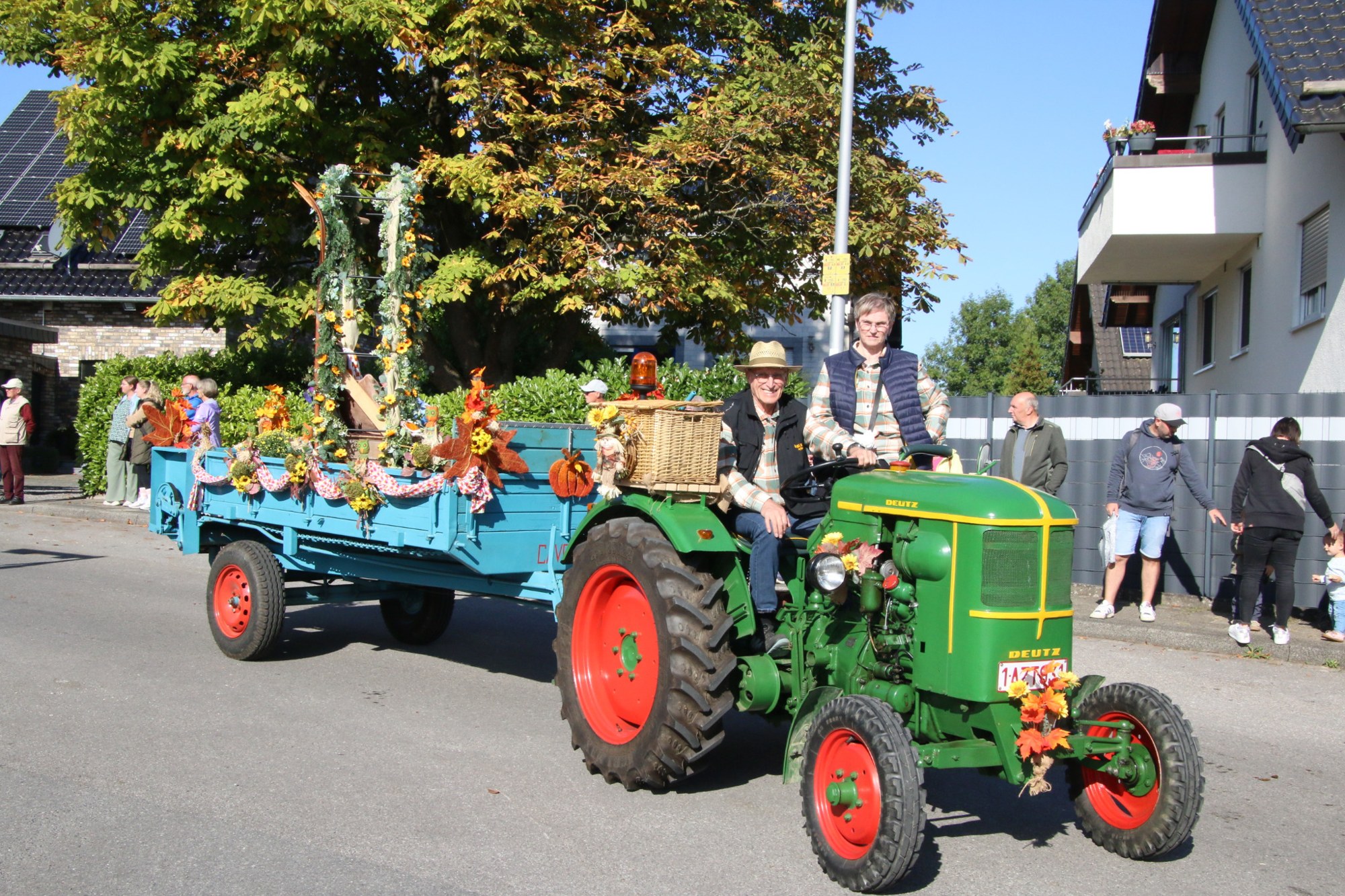 Grüner Traktor mit blauem Erntewagen beim Erntedankzug Walheim 2026.
