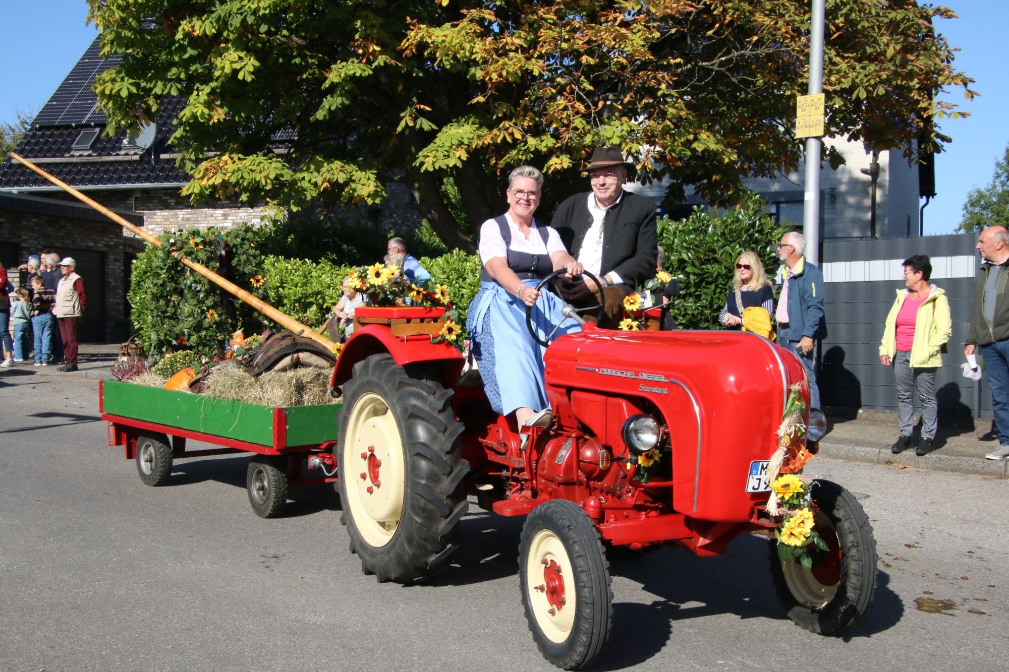 Roter Traktor mit Teilnehmern beim Erntedankzug Walheim 2026.
