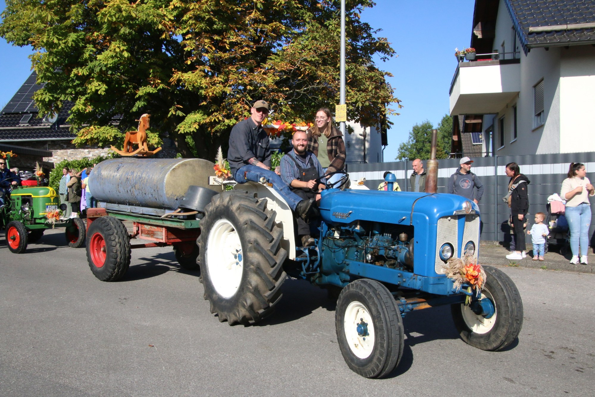 Blauer Oldtimertraktor mit landwirtschaftlichem Anhänger beim Erntedankzug Walheim 2026.