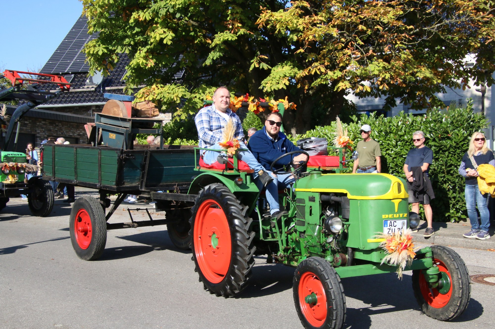 Grüner Traktor mit geschmücktem Wagen beim Erntedankzug Walheim 2026.