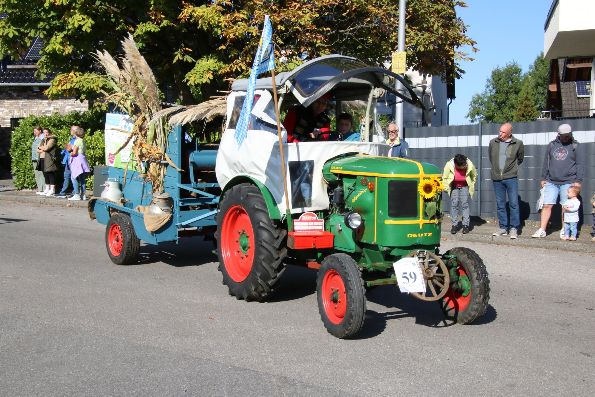 Grüner Traktor mit dekoriertem Wagen beim Erntedankzug Walheim 2026.