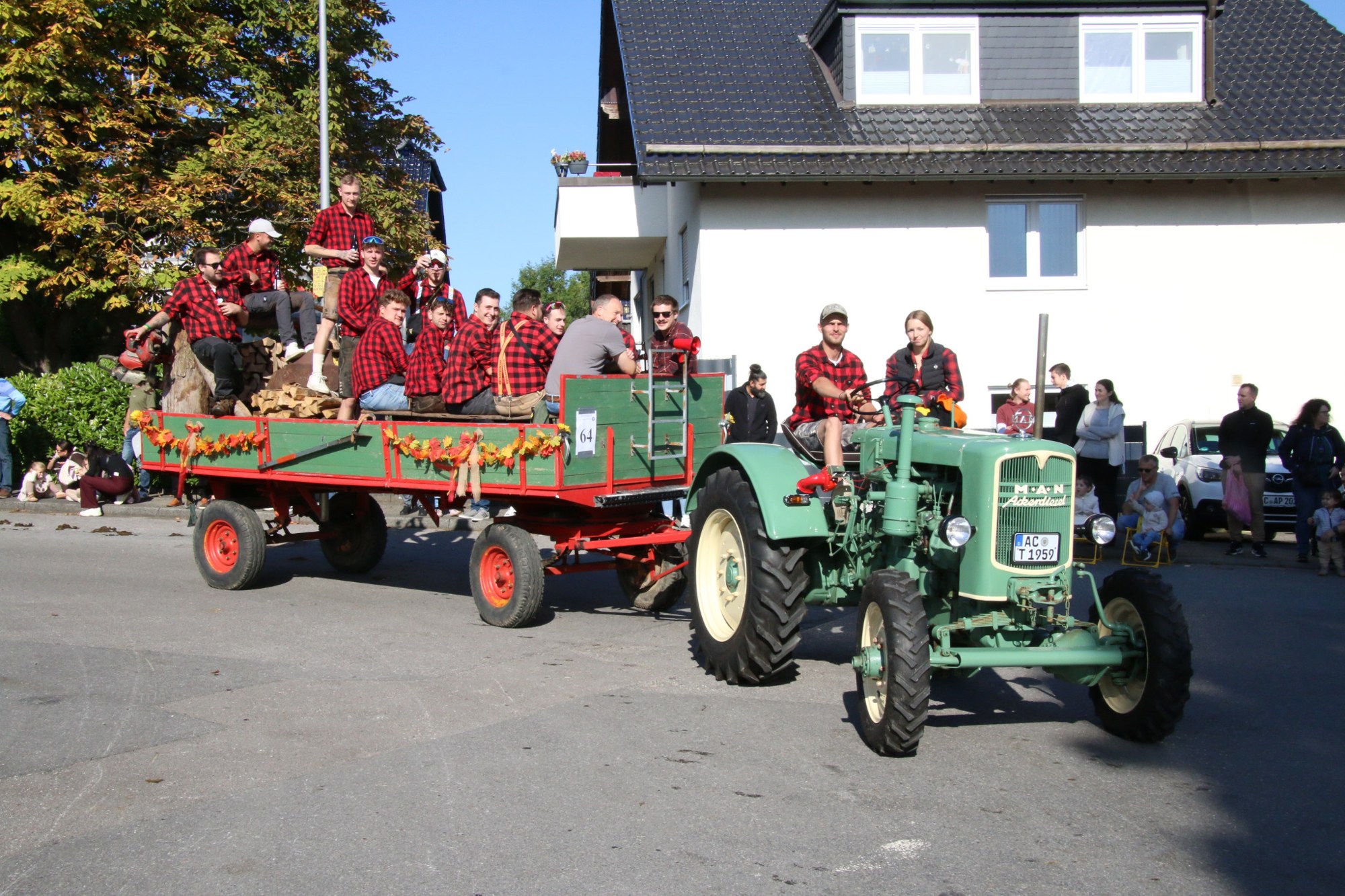 Traktor und Teilnehmer in rot karierten Hemden beim Erntedankzug Walheim 2026.