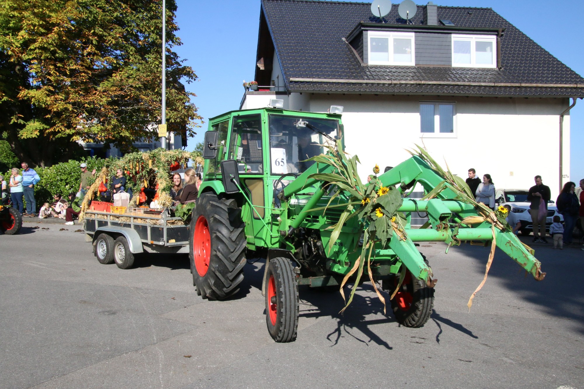 Grüner Traktor mit Ernteanhänger beim Erntedankzug Walheim 2026.
