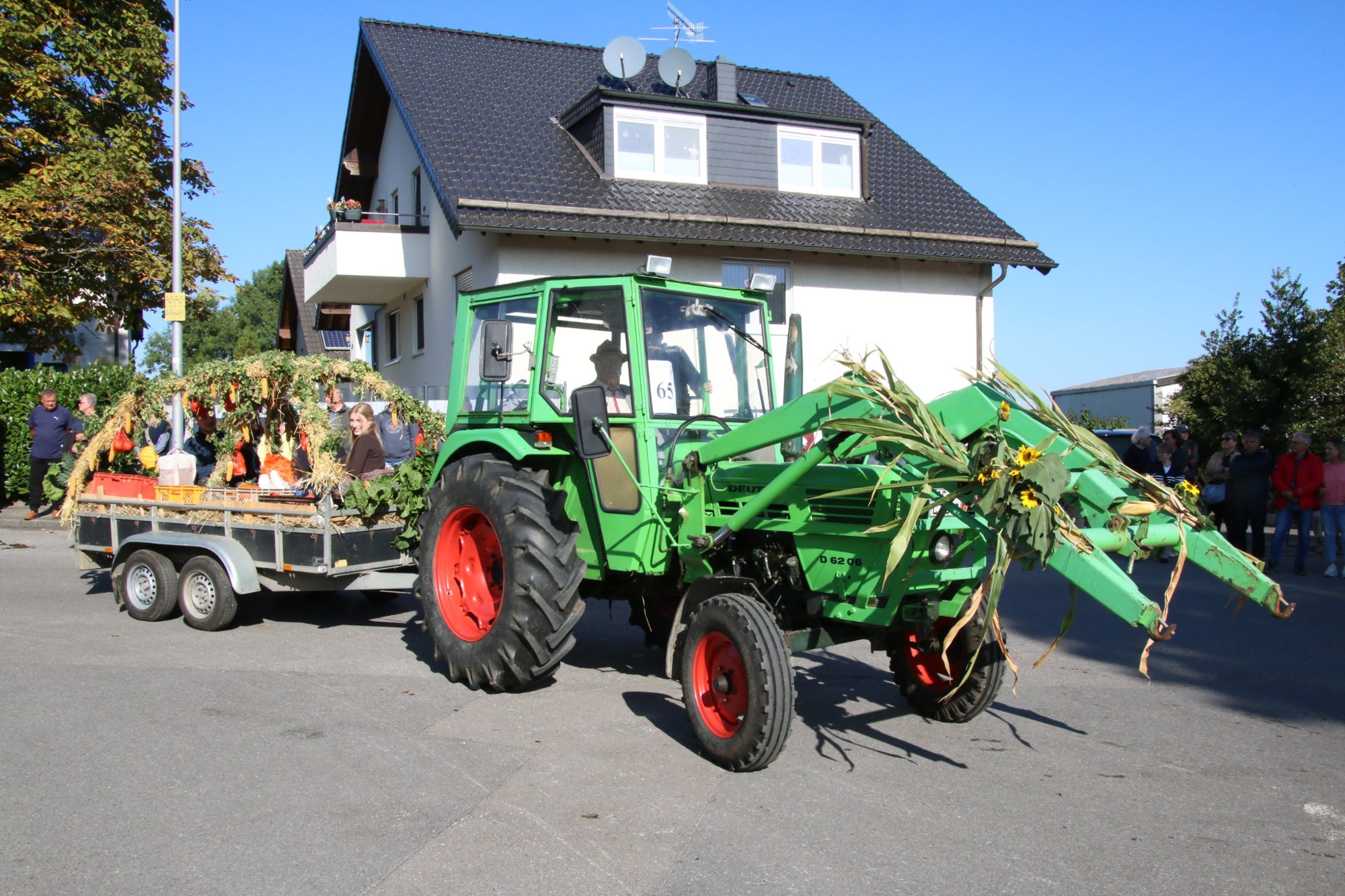 Grüner Traktor und Festwagen auf der Zugstrecke beim Erntedankzug Walheim 2026.