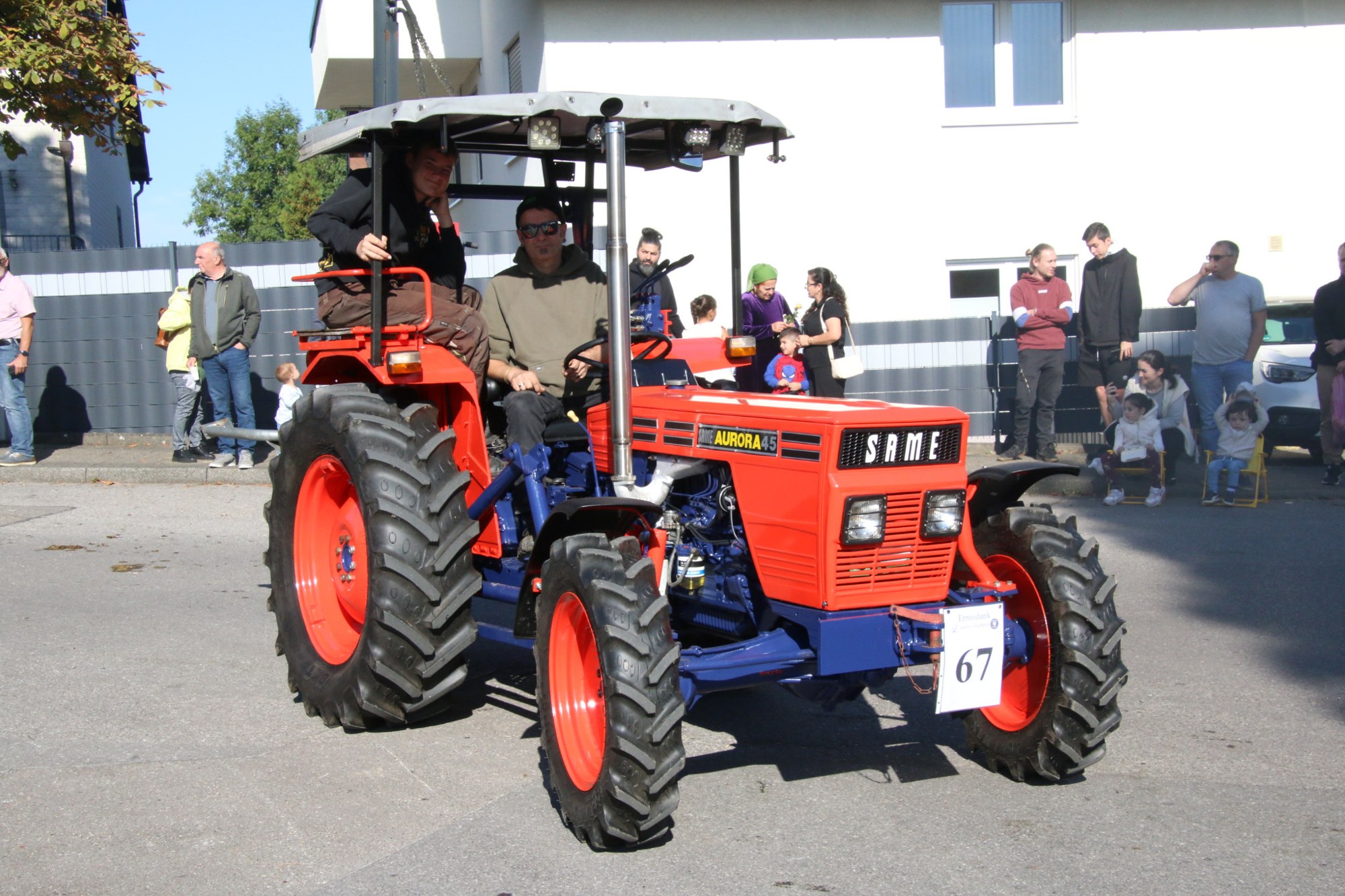 Roter Oldtimertraktor vor Zuschauern beim Erntedankzug Walheim 2026.