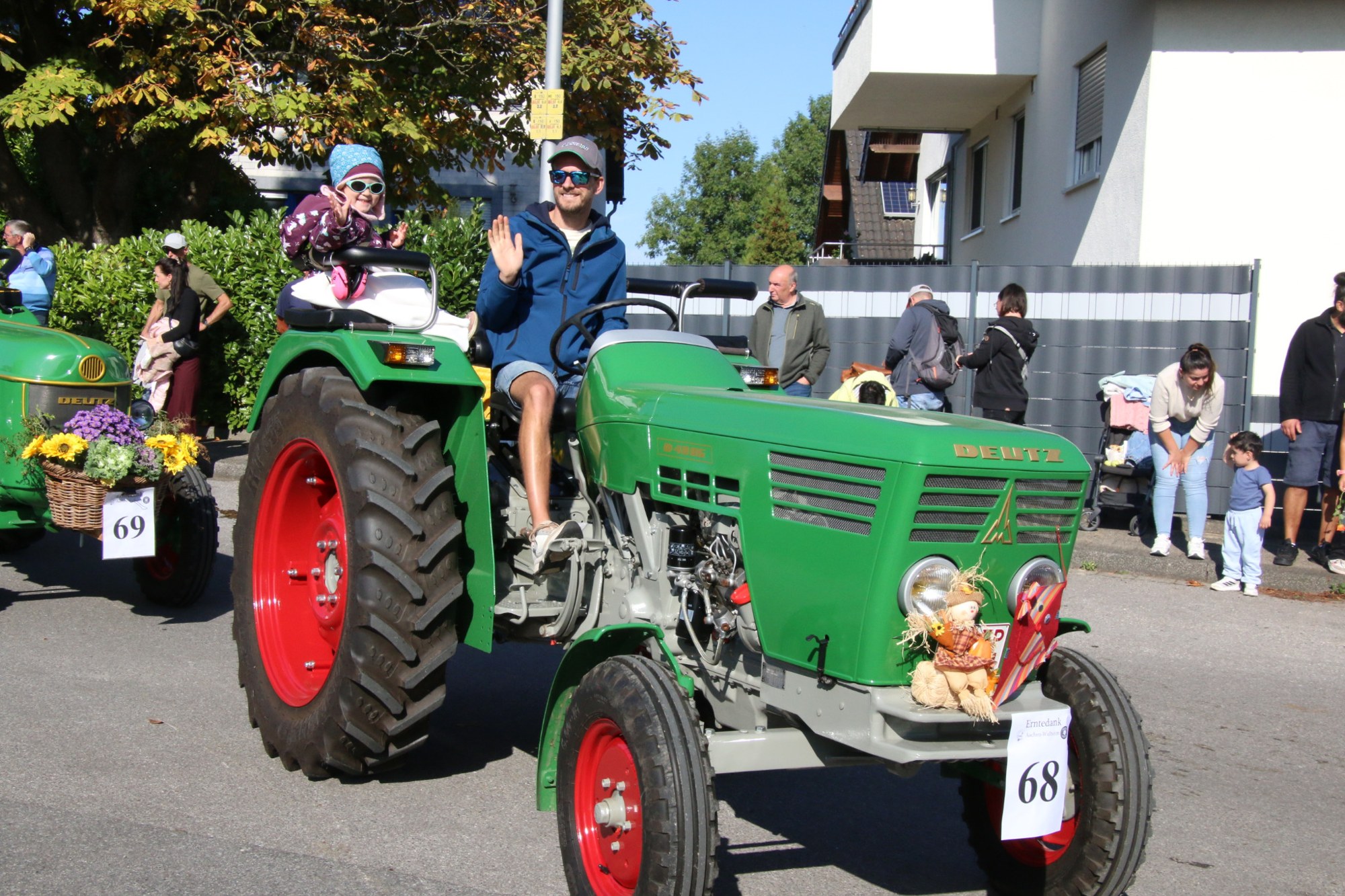 Teilnehmer auf einem grünen Oldtimertraktor beim Erntedankzug Walheim 2026.