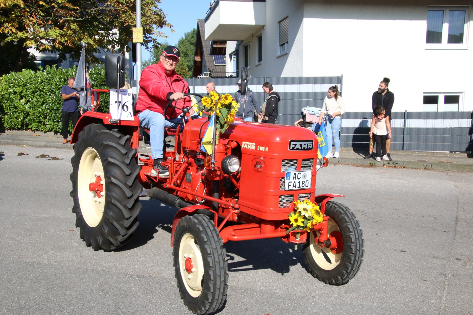 Roter Traktor mit Blumenkränzen beim Erntedankzug Walheim 2026.