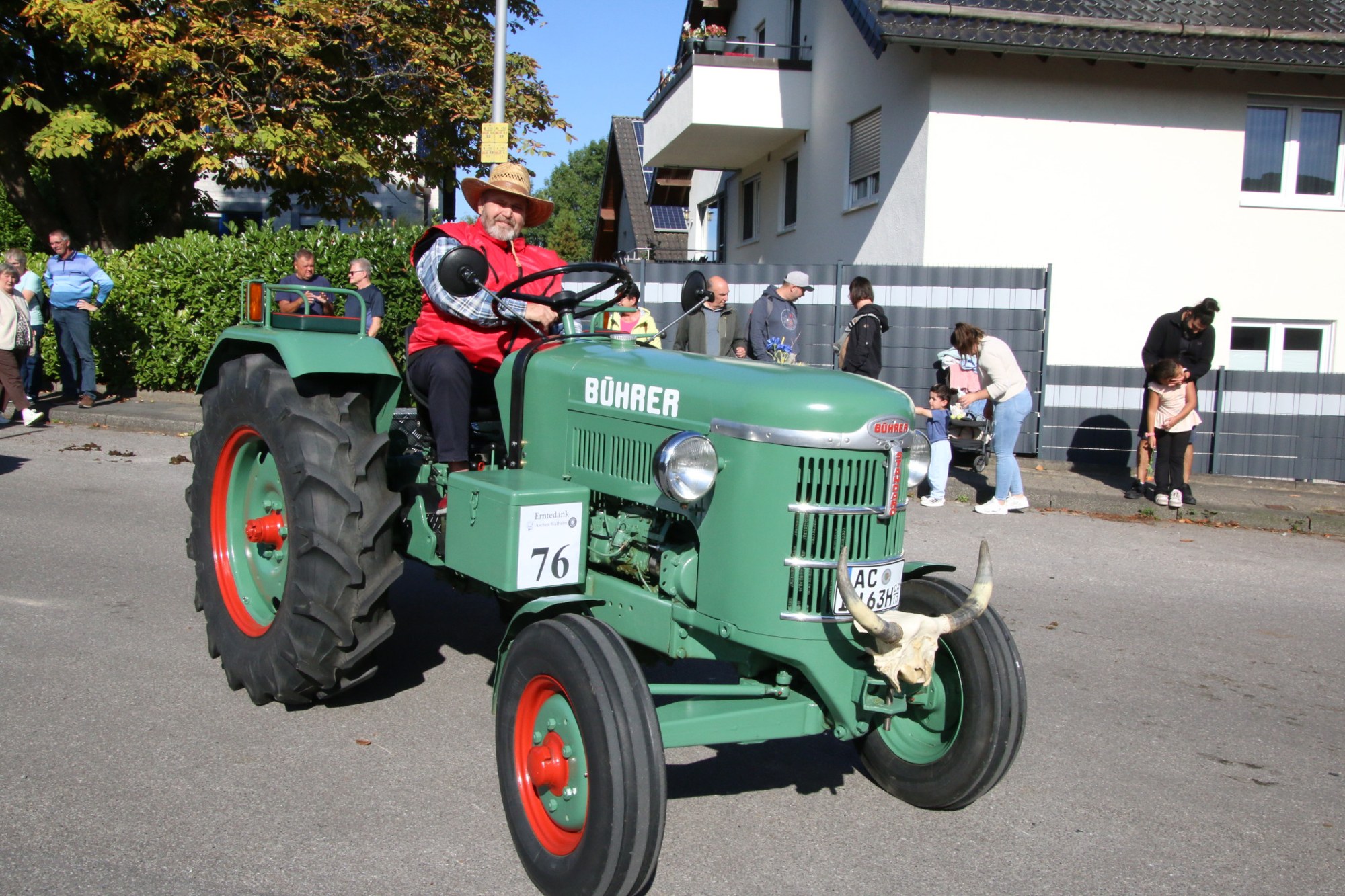 Hellgrüner Oldtimertraktor vor dem Publikum beim Erntedankzug Walheim 2026.